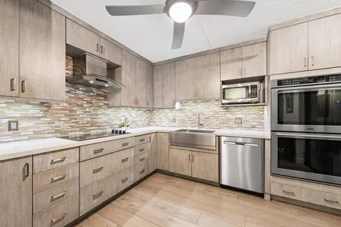 a kitchen with granite countertop cabinets stainless steel appliances and a sink