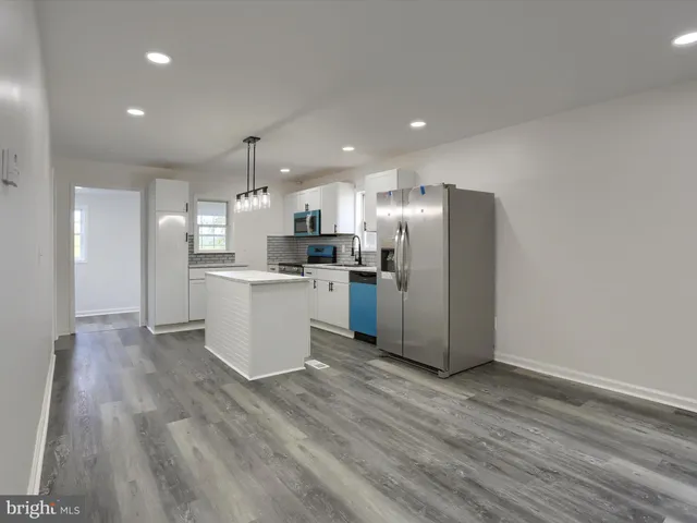 a kitchen with a refrigerator a sink and dishwasher with wooden floor