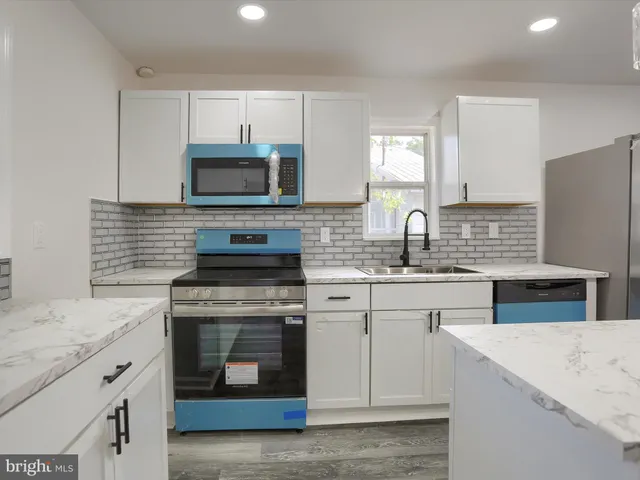 a kitchen with kitchen island white cabinets appliances and center island