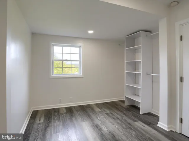 an empty room with wooden floor and window