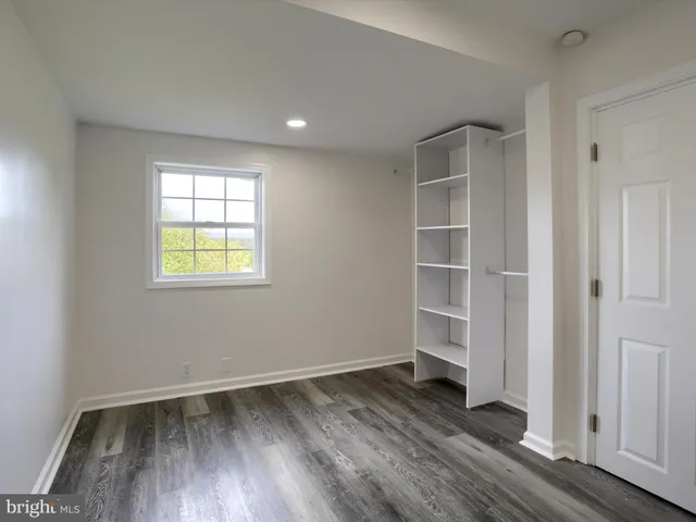 a view of a room with wooden floor and a bathroom