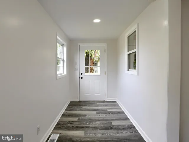 a view of a hallway with wooden floor and closet