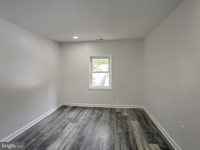 a view of a room with wooden floor and a bathroom