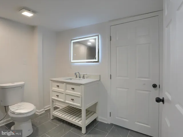 a bathroom with a sink a toilet and a mirror