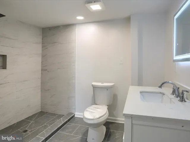 a bathroom with a sink a toilet a mirror and vanity