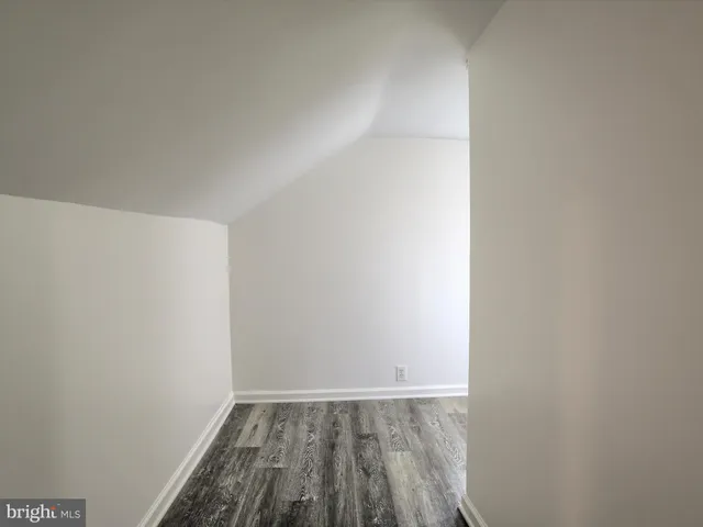 a view of a hallway with wooden floor and window