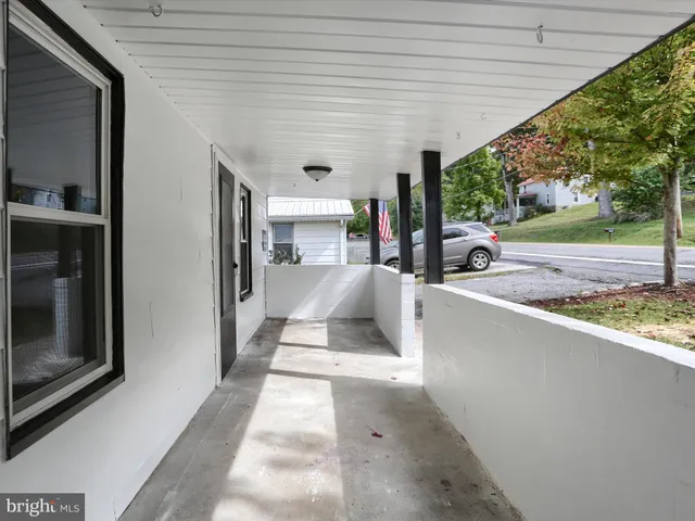 a view of a electric appliances in kitchen and empty room with wooden floor