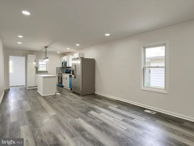 a view of a kitchen with a refrigerator and a stove top oven