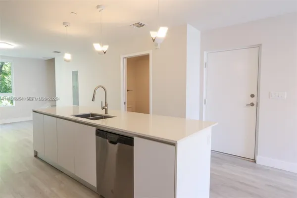 a kitchen with a sink a counter space and a window