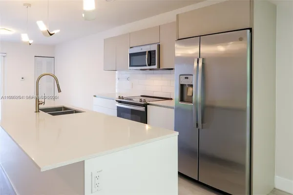 a kitchen with a refrigerator and a sink