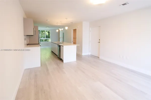 a view of kitchen with kitchen island and stainless steel appliances
