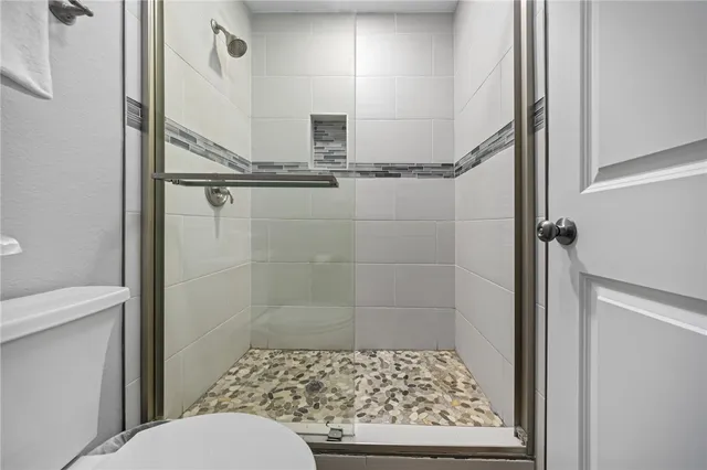 a bathroom with a toilet and a shower