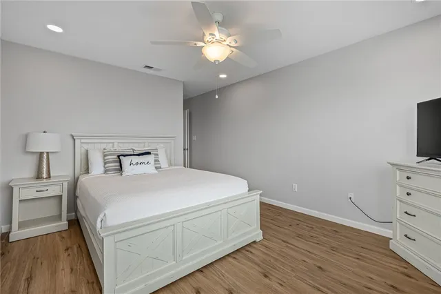 a bedroom with a bed and a flat tv screen on a dresser
