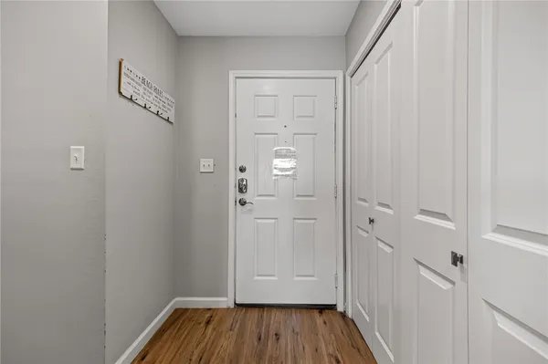 a view of a hallway with wooden floor and closet area