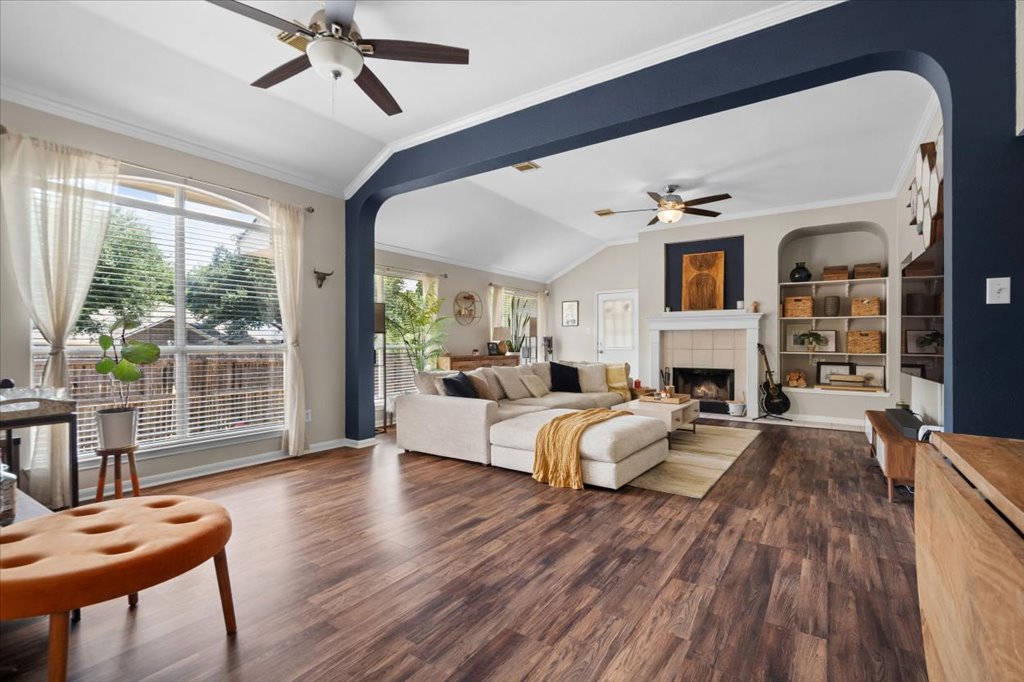 13200 Calf Roping Trail Austin, TX 78727 - Photo 11 of 28 Rich wood-look flooring stretches beneath an arched opening leading to a welcoming fireplace hearth.
