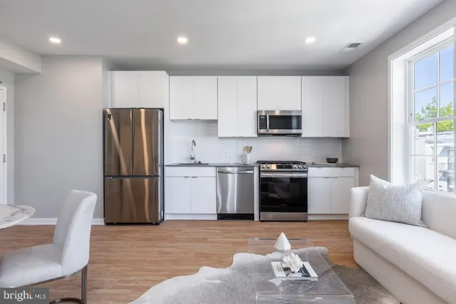 a kitchen with stainless steel appliances a stove a sink a refrigerator and a microwave