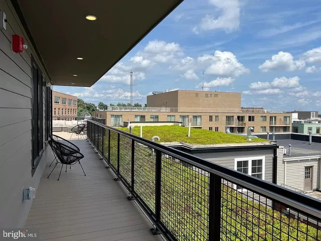 a view of a patio with a dining table and chairs with wooden floor