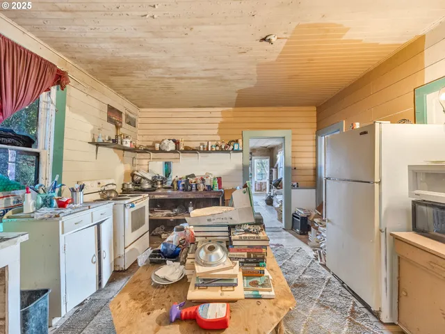 a living room with furniture a flat screen tv and kitchen view
