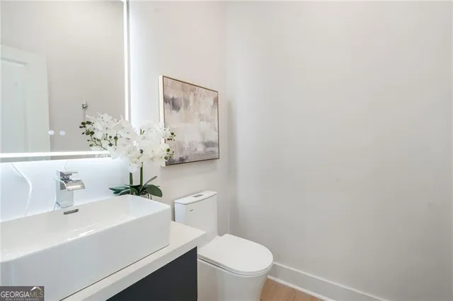 a bathroom with a sink a toilet and a mirror