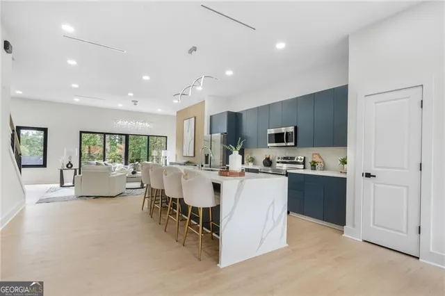 a large kitchen with kitchen island a sink a center island stainless steel appliances and cabinets