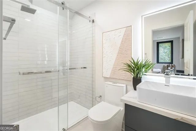 a bathroom with a sink a toilet and shower