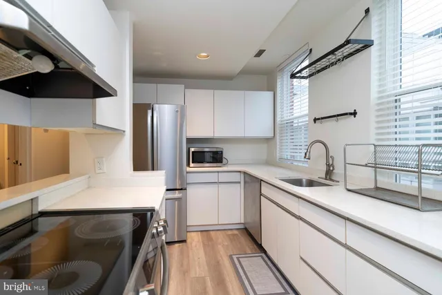 a kitchen with granite countertop a sink stainless steel appliances and cabinets