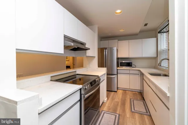 a kitchen that has a sink and a stove top oven