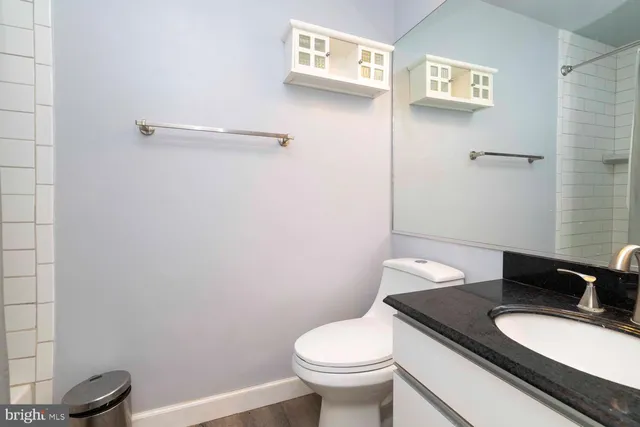 a bathroom with a granite countertop toilet and a sink
