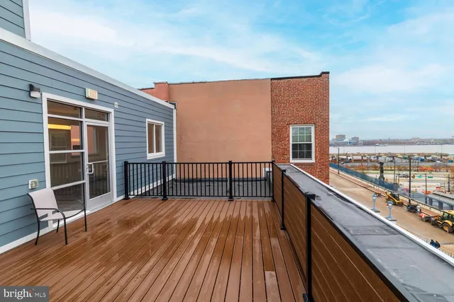 a balcony with wooden floor next to a yard