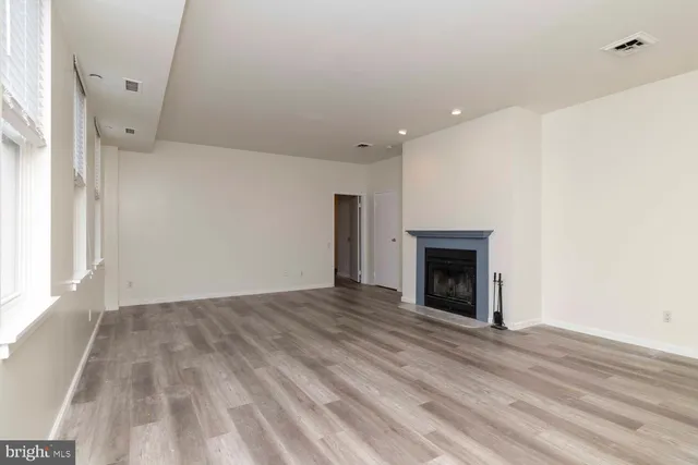 a view of empty room with wooden floor and fireplace