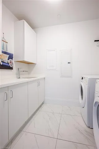 a utility room with cabinets washer and dryer
