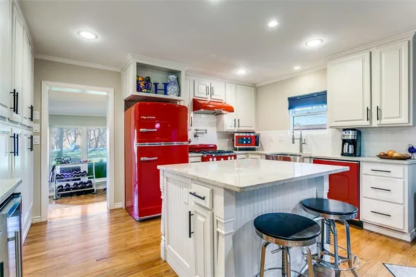 a kitchen with stainless steel appliances granite countertop a sink and a refrigerator