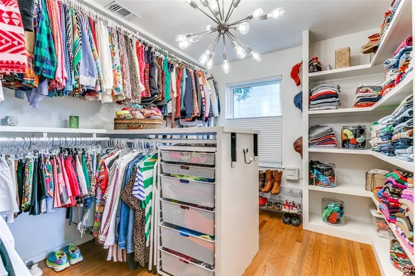 a view of walk in closet with clothes and shoes