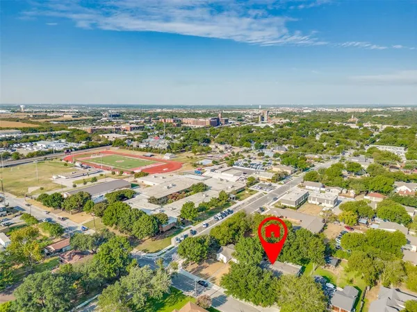 an aerial view of ocean and residential houses with outdoor space