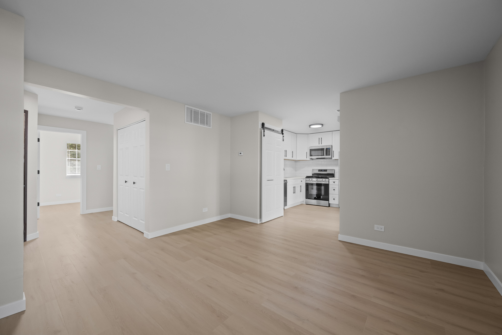 556 East Shag Bark Lane, Unit C Streamwood, IL 60107 - Photo 4 of 15 a view of empty room with wooden floor and kitchen