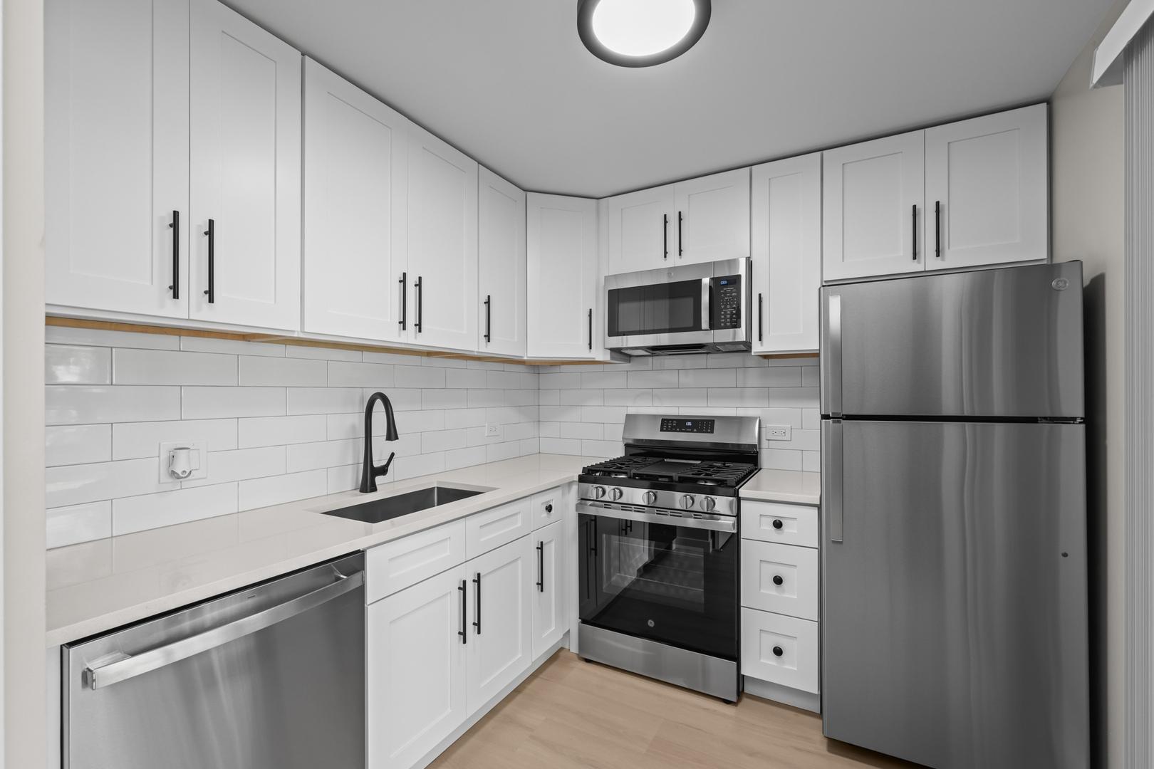 556 East Shag Bark Lane, Unit C Streamwood, IL 60107 - Photo 6 of 15 a kitchen with stainless steel appliances a refrigerator stove and microwave