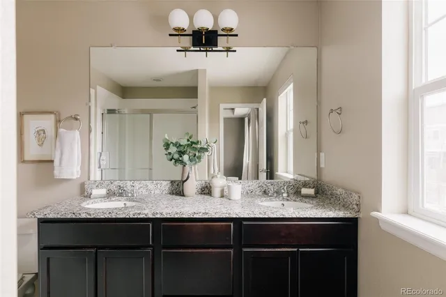 a bathroom with a granite countertop sink a mirror and vanity
