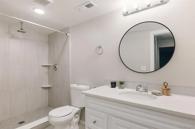 a bathroom with a sink a toilet and a mirror