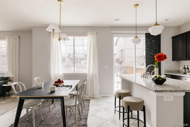 a kitchen with stainless steel appliances granite countertop sink window and dining table