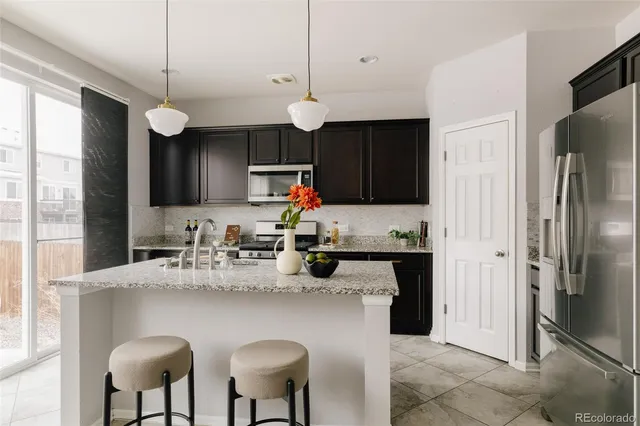 a kitchen with stainless steel appliances granite countertop a refrigerator a sink a stove a microwave and island