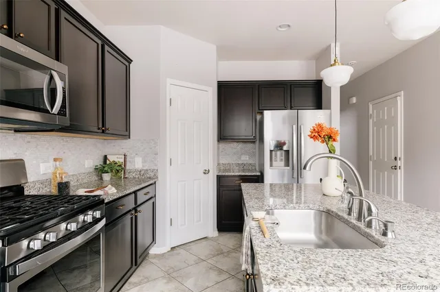 a kitchen with stainless steel appliances granite countertop a sink stove and refrigerator