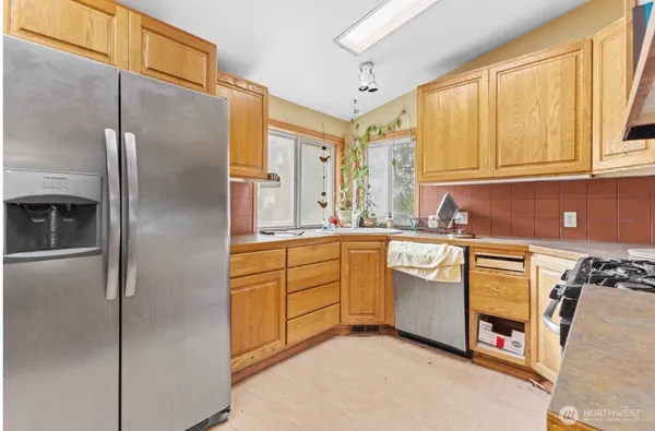 a kitchen with stainless steel appliances granite countertop a refrigerator and a sink
