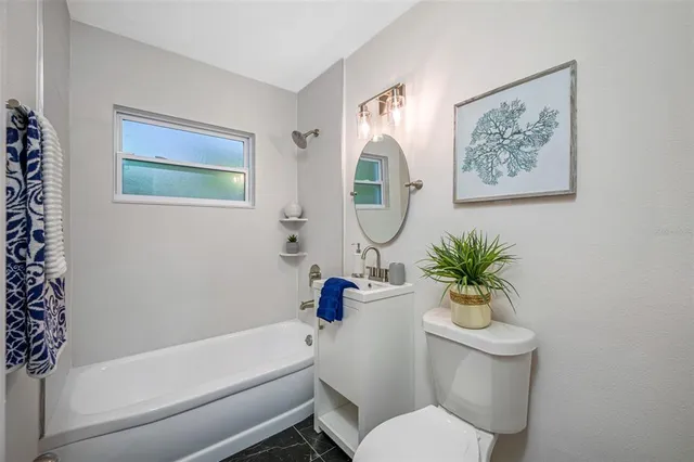 a bathroom with a toilet a sink and tub