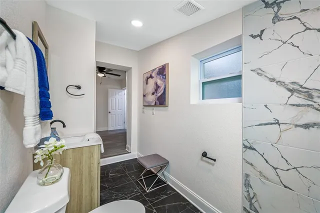 a bathroom with a sink mirror vanity and toilet