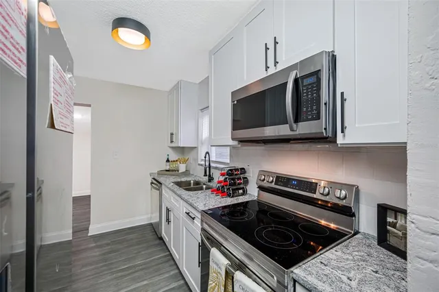 a kitchen with stainless steel appliances granite countertop a stove and a microwave