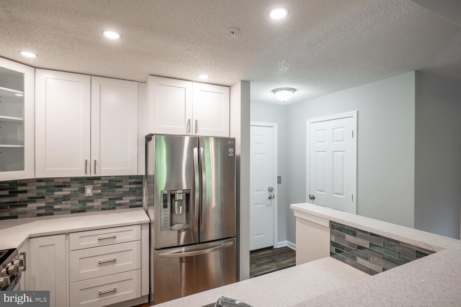 12024 Taliesin Place, Unit 33 Reston, VA 20190 - Photo 11 of 32 a kitchen with stainless steel appliances a refrigerator and cabinets
