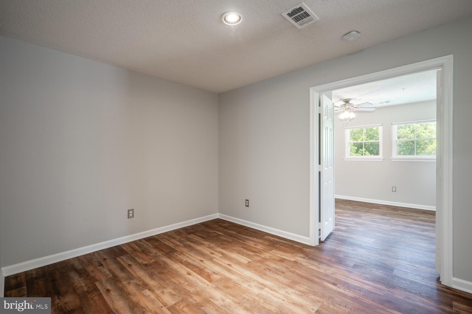 12024 Taliesin Place, Unit 33 Reston, VA 20190 - Photo 12 of 32 an empty room with wooden floor and windows