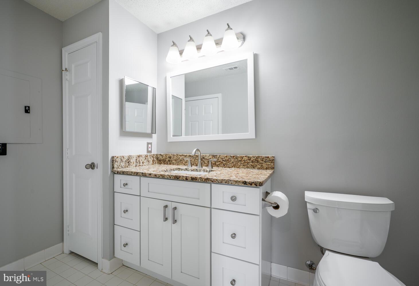 12024 Taliesin Place, Unit 33 Reston, VA 20190 - Photo 17 of 32 a bathroom with a granite countertop toilet sink and mirror