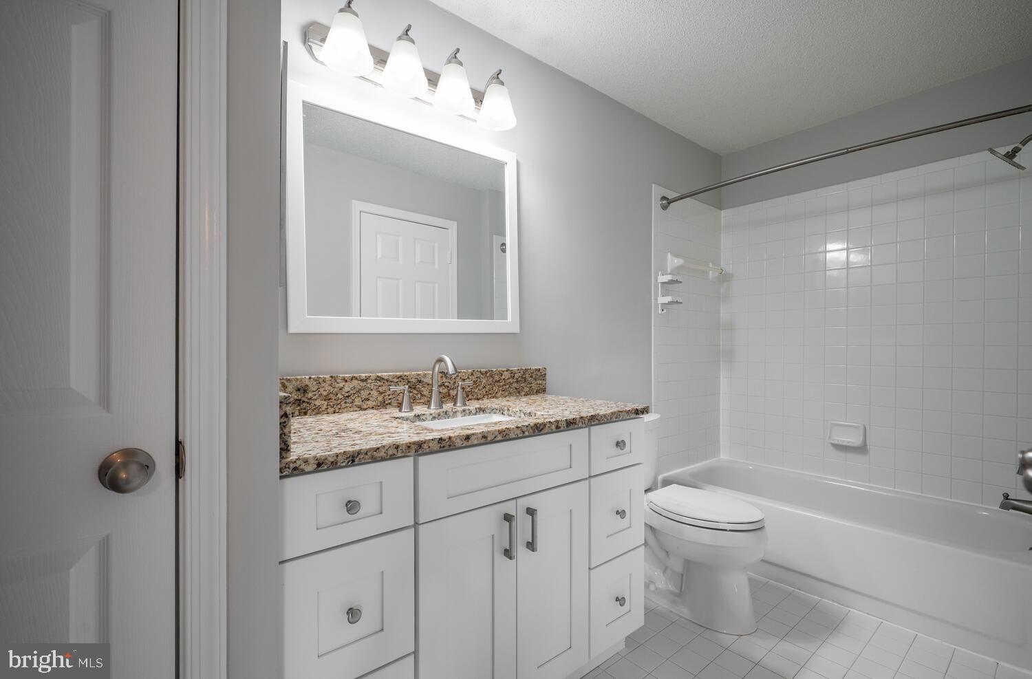12024 Taliesin Place, Unit 33 Reston, VA 20190 - Photo 18 of 32 a bathroom with a toilet a sink a mirror a shower and vanity