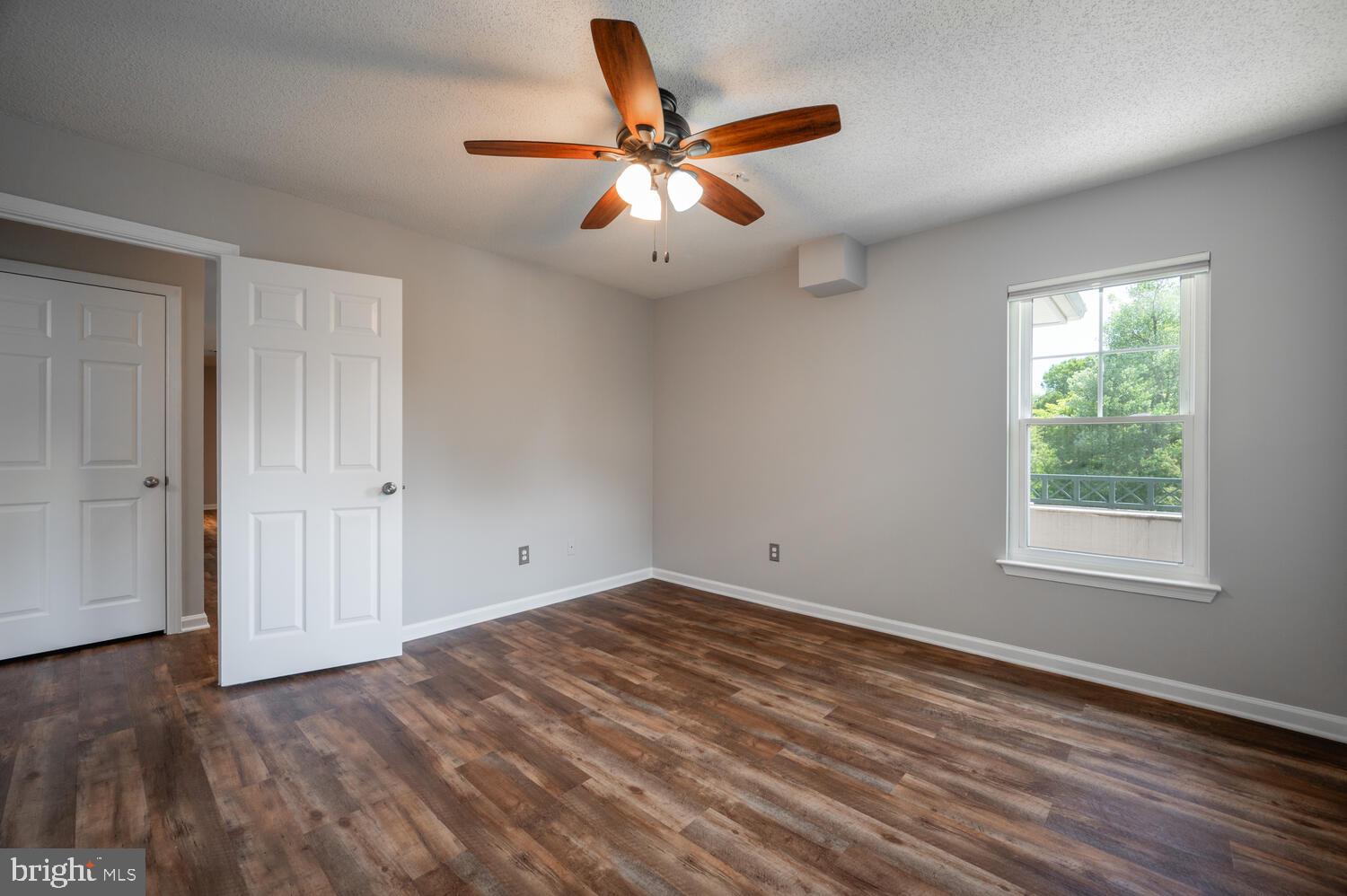 12024 Taliesin Place, Unit 33 Reston, VA 20190 - Photo 20 of 32 an empty room with wooden floor fan and windows